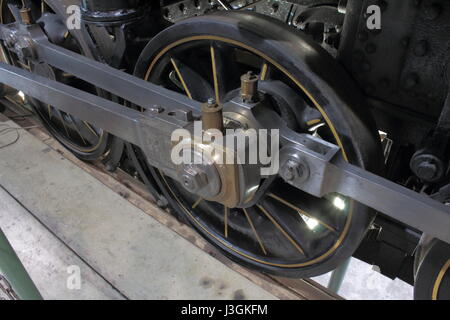 A steam locomotive wheel with the connecting rods show the power in these old steam engines.  It was a big job keeping all these pieces lubricated. Stock Photo