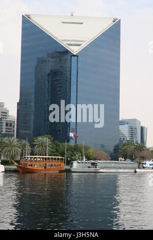 Lots of ships on a sea canal in Dubai. A view at famous skyscrapers from touristic boat. Blocks of flats and office buildings are high, unusual shape. Stock Photo