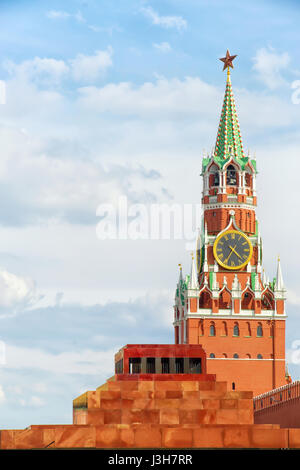 Red square, Moscow, Russia. Spasskaya tower of Kremlin with star and clock and Lenin's Mausoleum. Vertical composition, copy space on the cloudy sky.  Stock Photo