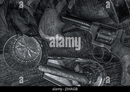 Thompson gun, revolver, cigar on ashtray, whiskey glass and blue feather boa. Black and white Stock Photo