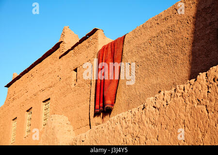 Drying carpet on the earthen walls of the house, Morocco Stock Photo