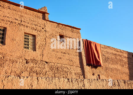 Drying carpet on the earthen walls of the house, Morocco Stock Photo