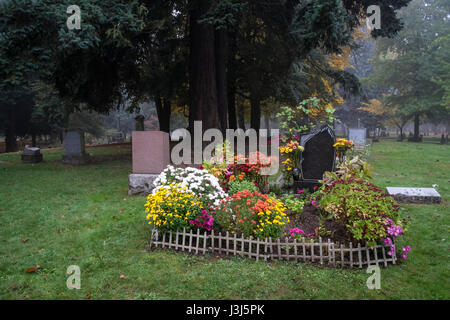 Gravesite in an old Pioneer Cemetery full of flowers Stock Photo