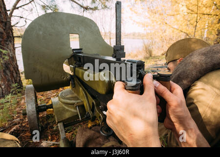 Reenactors Dressed As Russian Soviet Red Army Soldiers Of World War II Hidden Sitting With Maxim's Machine Gun Weapon In An Ambush In Autumn Forest Stock Photo