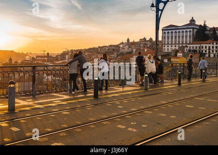 Tourists Porto Portugal, view people standing on the Ponte Dom Luis I bridge and watching a sunset over the city of Porto, Portugal, Europe Stock Photo