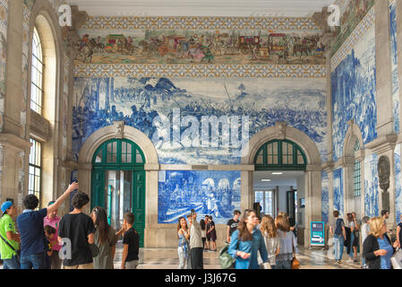 Train station Porto Portugal, view of the entrance hall of the Sao Bento train station decorated with blue azulejo tiles depicting historical scenes. Stock Photo