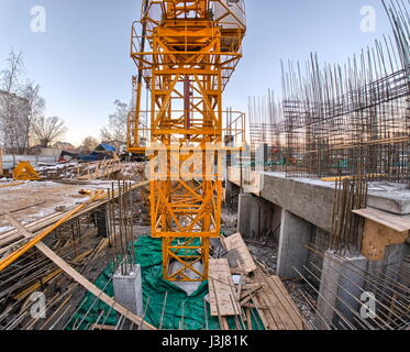 yellow crane and the building under construction on the blue sky Stock Photo