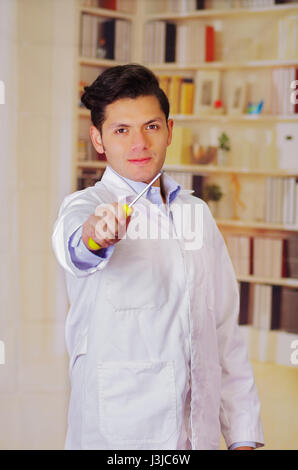 Handsome man wearing a white coat and holding a screwdriver. Stock Photo