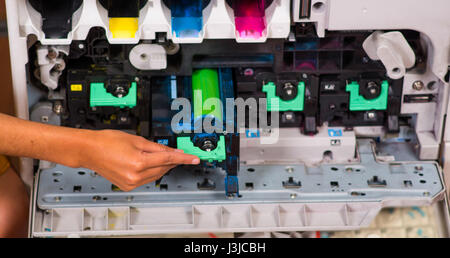 Smart woman fixing a photocopier during maintenance. Stock Photo