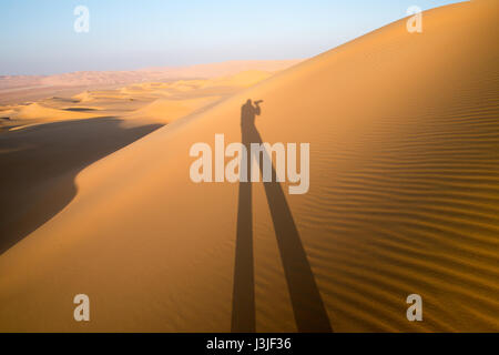 Liwa Oasis, Abu Dhabi , United Arab Emirates -, shadow of hiker in the sand dunes of the desert   The Empty Quarter (Rub' al Khali) of the arabian pen Stock Photo