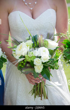 Bride holding her bouquet of white and green flowers at a golf course wedding in Oregon. Stock Photo