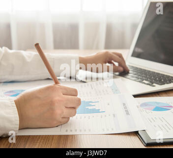 Businessmen are analyzed data from report and a laptop computer. Stock Photo
