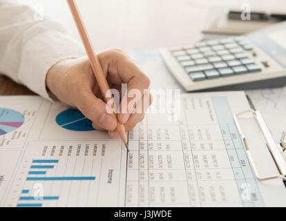 Businessmen are analyzing the data from the report. Stock Photo