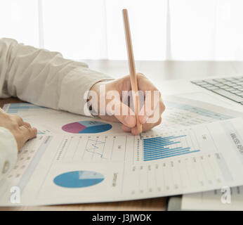 Businessmen are analyzing the data from the report. Stock Photo