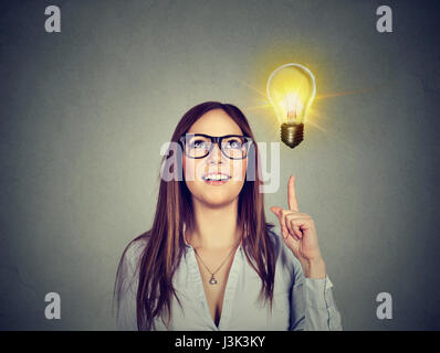 Portrait of woman pointing at bright light bulb. Success growing business concept Stock Photo