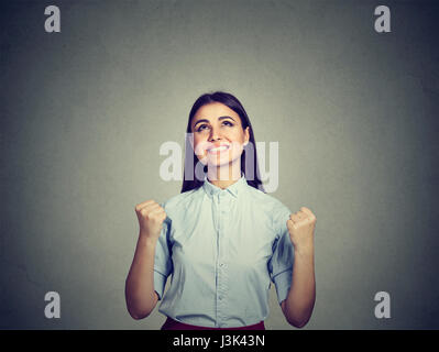 Portrait of a successful woman with fists pumped celebrating success isolated on gray wall background. Life perception reaction Stock Photo