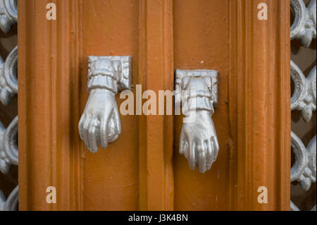 close up of door handles shaped like hands Stock Photo