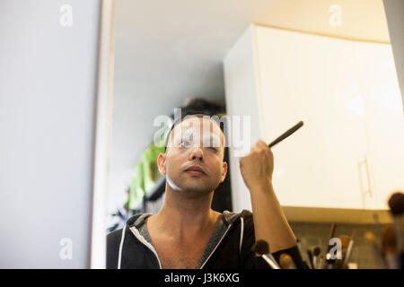 Young man applying drag makeup Stock Photo