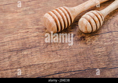 Wooden honey dippers on wooden background. Stock Photo