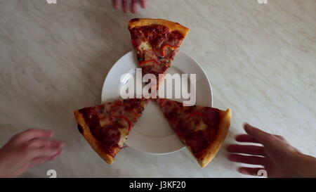Hands take a plate of pizza slices. Stock Photo