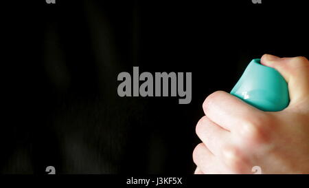 Aerosol can being sprayed against a black background Stock Photo - Alamy