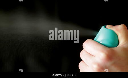 Aerosol can being sprayed against a black background Stock Photo - Alamy