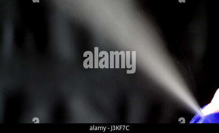 Aerosol can being sprayed against a black background Stock Photo - Alamy