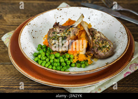 Rosemary lamb chops dinner with carrot and parsnip mash and green peas Stock Photo