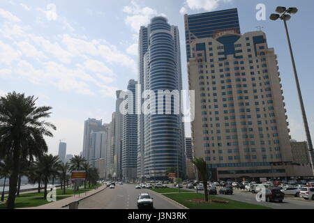 Sharjah is the third largest emirate in the United Arab Emirates. Lots of mighty skyscrapers with glass facades, palm trees, mosques. Nice garden, bay Stock Photo