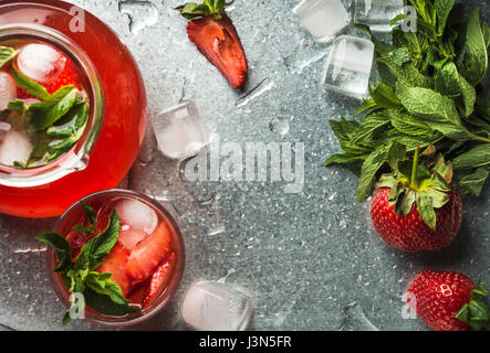 Homemade strawberry lemonade with mint, ice and fresh berries over metal tray background, top view, copy space Stock Photo
