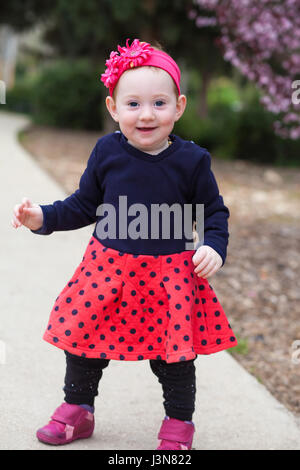 Portrait of cute baby girl standing on a park path