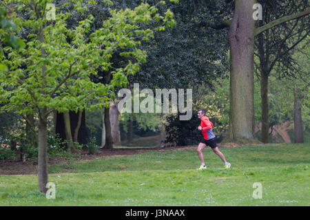 Abington Park, Northampton, 6th May 2017. Weather, a grey damp start this morning which is forecast for the rest of the day. Lone jogger along Park Ave South which runs through Abington Park. Credit: Keith J Smith./Alamy Live News. Stock Photo