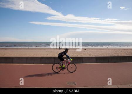 Edinburgh, Scotland, UK. 06th May, 2017. Man cycling on the promenade of Portobello beach in Edinburgh, Scotland, UK. Weather: 6. may 2017 Temperatures peaking above seasonal averages away from the coasts, particularly in West Lothian. However it will be cloudier than Friday, particularly across the south throughout and later over the east coast where some low cloud develops. Credit: Gabriela Antosova/Alamy Live News Stock Photo