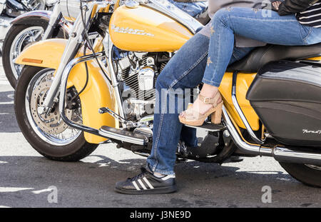 Woman riding pillion, passenger on Harley Davidson motorbike. Stock Photo
