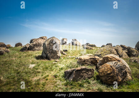 Sunset over rocks formations in Dobrogea, Tulcea county, Romania. Naturally formed piles of large rocks in Macin Mountain, the olders alps in Europe. Stock Photo