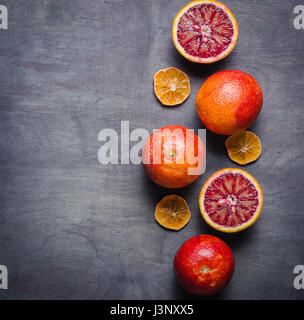 Several oranges of orange and red on a black background. View from above. Minimalistic design. Stock Photo