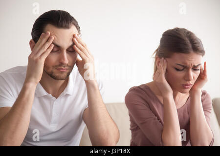 Stressed young couple suffering from headache, touching head, fe Stock Photo