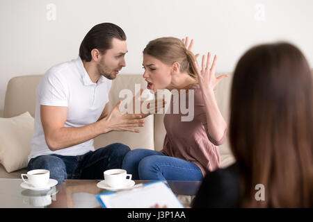 Family psychologist counseling. Couple quarrelling, shouting and Stock Photo