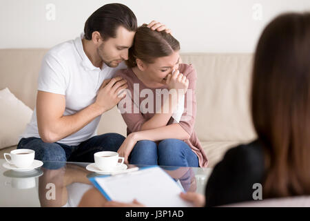 Family couple counseling. Husband comforting sad crying wife at  Stock Photo
