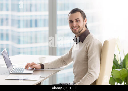 Smiling businessman working at office, looking at camera, using  Stock Photo
