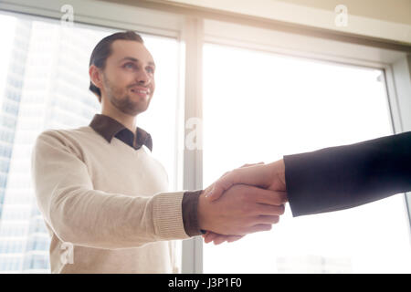 Handsome young businessman shaking female hand, deal or business Stock Photo