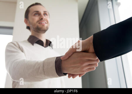 Close up of handshake, smiling businessman and client shaking ha Stock Photo