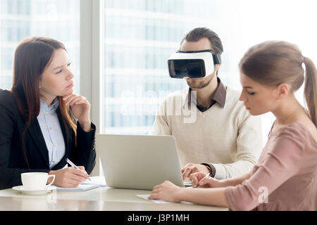 Business team testing VR-ready laptop, developing virtual realit Stock Photo