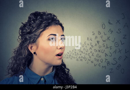 Woman talking with alphabet letters coming out of her mouth. Communication, information, intelligence concept Stock Photo