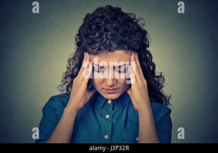 Closeup portrait worried sad young looking down isolated on gray wall background Stock Photo