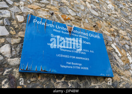 Neglected dilapidated name sign on exterior of Petworth United Reformed Church, Petworth, West Sussex, peeling paint, blistered wood, falling apart Stock Photo