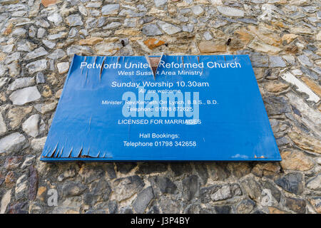 Neglected dilapidated name sign on exterior of Petworth United Reformed Church, Petworth, West Sussex, peeling paint, blistered wood, falling apart Stock Photo