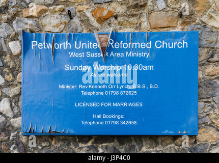 Neglected dilapidated name sign on exterior of Petworth United Reformed Church, Petworth, West Sussex, peeling paint, blistered wood, falling apart Stock Photo