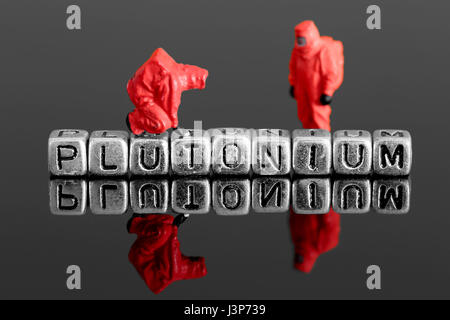 Miniature scale model team in chemical suits with the word plutonium on beads Stock Photo
