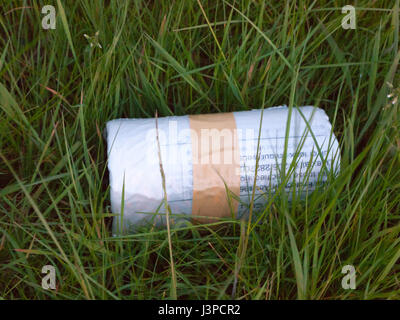 tied up taped recycling bag roll on the grass lawn Stock Photo